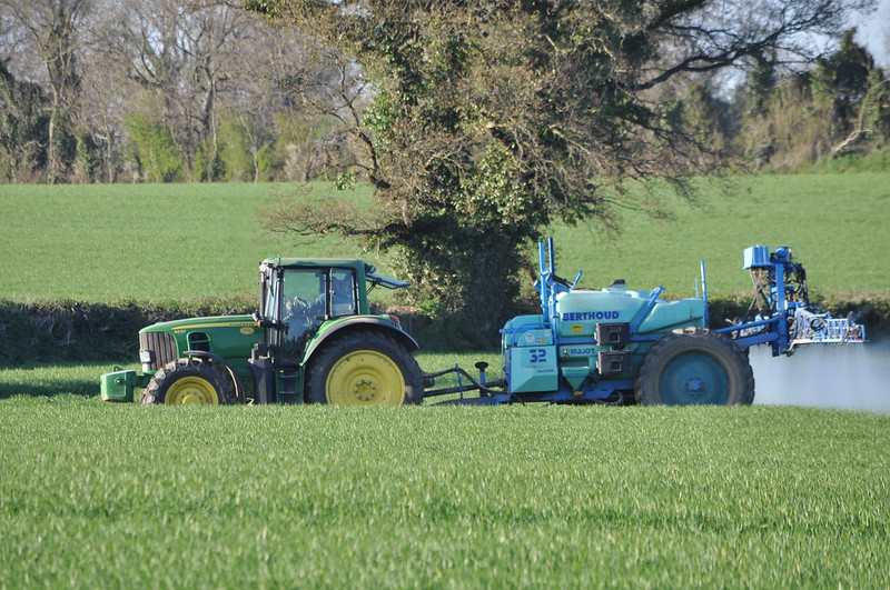 A tractor spraying pesticides on a crop